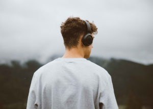a man with headphones on looking at the mountains — Foto por Ciocan Ciprian na Unsplash
