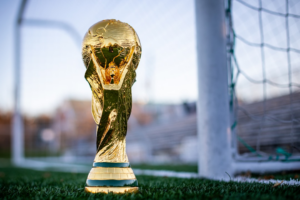 a golden soccer trophy sitting on top of a field — Foto por My Profit Tutor na Unsplash