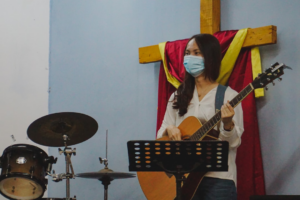 woman in white long sleeve shirt playing guitar — Foto por Marscella Ling na Unsplash