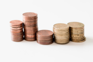 stacked round gold-colored coins on white surface — Foto por Ibrahim Rifath na Unsplash